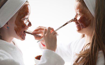 Kinder bemalen sich gegenseitig mit Schokoladenmaske im Gesicht