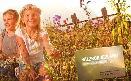 Kinder in Blumenwiese mit der Salzburger Land Card