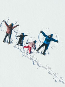 Familie beim Schneeengel machen