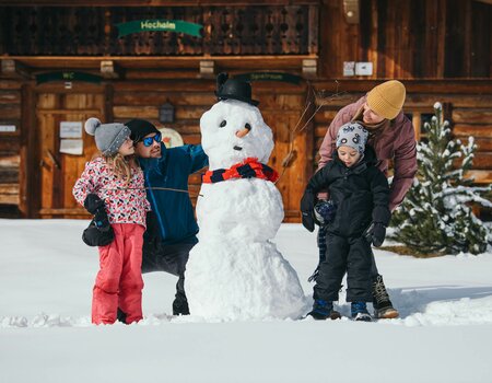 Familie baut einen Schneemann