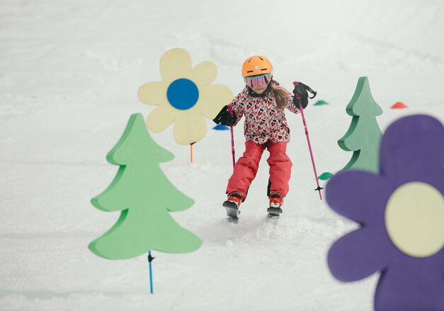 Kind fährt die Skiwiese hinab